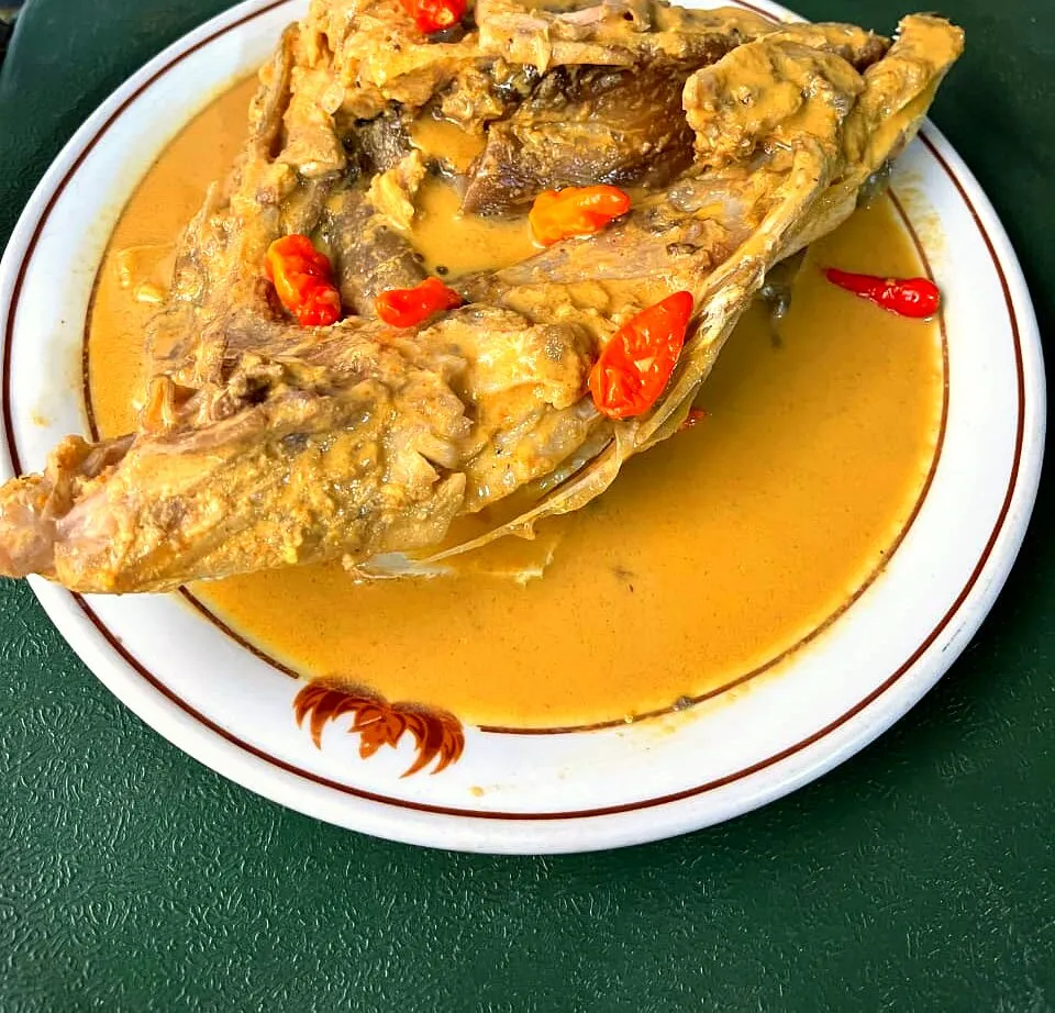 Gulai kepala kakap — snapper head curry in rich yellow spice sauce